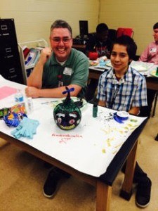Andy Chenoweth (left), with Sparks Health System, works with Wilfredo Fajardo. They painted pumpkins for Halloween.