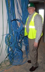Kyle Parker, president and CEO of the Arkansas Colleges of Health Education, holds part of the more than 45 miles of wiring for computers and associated peripherals.