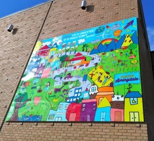 Designed by all 568 students at Parson Hills Elementary School in Springdale – and documented by Springdale’s Helen Tyson Middle School EAST Initiative students – this mural is mounted on the east wall of First Security Bank in Shiloh Square. It faces the Razorback Greenway Trail, as well as what will become a public gathering green space. (photo by Jamie Smith)