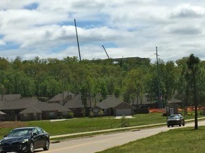 Steel for the new Arcbest corporate headquarters building at Chaffee Crossing emerges from the treeline above a residential area.