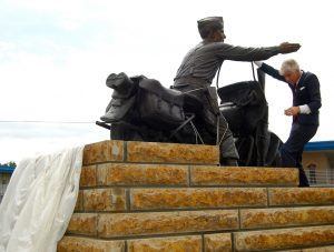 Darby statue sculptor Kevin Kresse helps the Darby family with the unveiling.