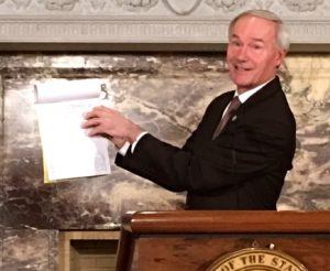 Gov. Asa Hutchinson on Thursday showed reporters where he executed a line-item veto on SB121, which is the funding legislation for his Arkansas Works program.