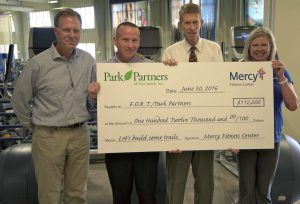 Friends of Recreational Trails Committee Members accept a contribution from Mercy Fitness Center for the Fort Smith trail system. Pictured (left to right) are Bill Hanna (FORT Committee), Doug Reinert, Fort Smith director of Parks & Recreation, Drew Linder (FORT Committee), and Paula Lind, with Mercy Fitness Center.