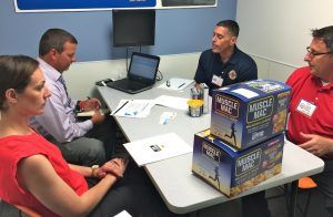 Business owners of Quality Pasta in Charleroi, Penn., Paul DeStefano and Peter Kroner (right) and their consultant Zara Kinsella pitch Muscle Mac to Sam’s Club buyer Peter O’Grodnick during Tuesday’s Open Call in Bentonville. The group also pitched to Wal-Mart and was told to come back this fall when buyer Ryan Isabell would try to find shelf space for Muscle Mac in stores.