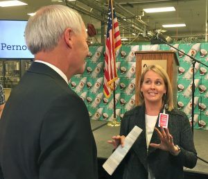 Cindi Marsiglio, vice president of U.S. Manufacturing for Bentonville-based Wal-Mart Stores, talks to Arkansas Gov. Asa Hutchinson on Monday after announcing Wal-Mart would buy Malibu Rum made at Pernod-Ricard’s Fort Smith facility.