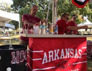 (from left) Tusk to Tail stalwarts Dale Cullins and David Rice prep the tailgate bar prior to the game in Fayetteville against Ole Miss.